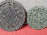 deux vieilles plaques métalliques posées l'une à côté de l'autre sur une surface rouge