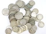 une pile de vieilles pièces d'argent sur une surface blanche