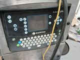 une machine posée au sol, équipée d'un tuyau