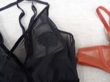 a black bra top and a red purse on a bed