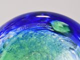 a blue and green glass vase sitting on a table