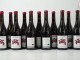 six bouteilles de vin sont alignées sur une table
