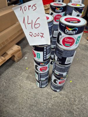 Plusieurs pots de peinture sont empilés les uns sur les autres dans un entrepôt