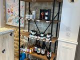 a wine rack in the corner of a kitchen with bottles on it