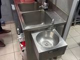 a kitchen with a sink and a trash can in it
