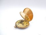 an image of a pocket watch with a gold case sitting on a white surface