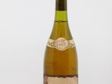 une vieille bouteille de vin posée sur une table blanche