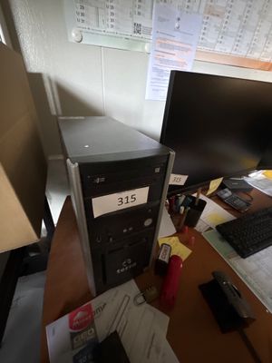 un ordinateur de bureau posé sur un bureau, à côté d'un écran d'ordinateur
