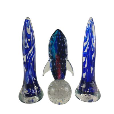 trois figurines de poissons en verre posées les unes à côté des autres