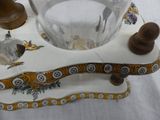 a glass bowl on a stand with a wooden handle