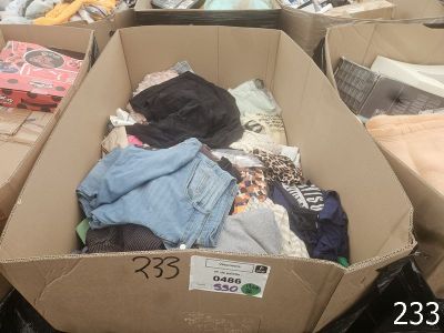 une boîte en carton pleine de vêtements posée sur le sol