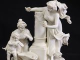 a figurine of a man and a woman on a pedestal
