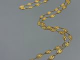 a close up of a gold necklace on a gray surface