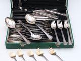silverware in a green case with spoons and forks in it