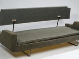a couch that is sitting on a metal stand
