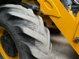 a large yellow tractor with a big tire on the back