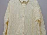 a yellow shirt hanging on a hanger on a wall