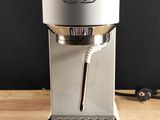 a silver coffee maker sitting on a wooden table