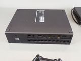 a black computer sitting on a table next to a game controller