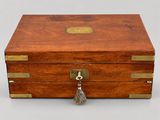 an old wooden box with a tassel on top of it