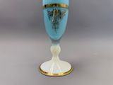 un vase bleu orné d'une décoration dorée