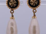 a pair of pearl and gold earrings with black and white pearls