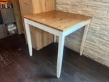 a white table with a wooden top in a room