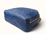 the large blue bag is sitting on a white surface
