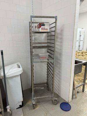 une photo d'une cuisine avec une étagère et une poubelle