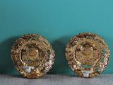 pair of gold plated earrings with pearls on them on top of a table