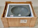 une caisse posée par terre, avec un lavabo à l'intérieur