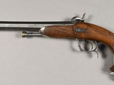 an old gun with a wooden handle on a white surface