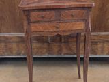 a small table with a drawer on it in front of a cabinet