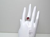 une main de mannequin blanche ornée d'une bague rouge
