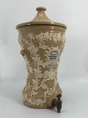 une image représentant un vase marron et blanc muni d'un couvercle