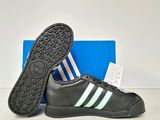 a pair of black and white adidas sneakers with a blue box