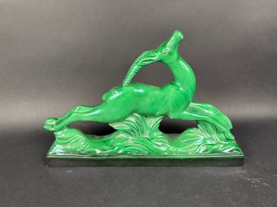 une statue verte représentant un cerf avec un oiseau perché sur son dos