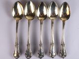 six spoons are lined up in a row on a white surface