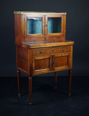 une vieille armoire en bois avec des portes vitrées et des tiroirs