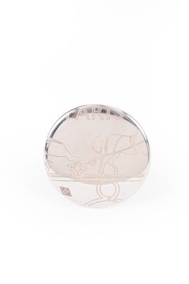 un gros plan d'une bague en argent sur laquelle est gravé un dessin