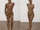a pair of wooden sculptures of a man and a woman