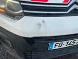 une camionnette blanche avec une bande rouge à l'avant