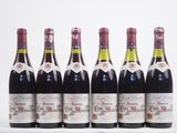 six bouteilles de vin sont alignées dans une rangée