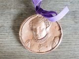 a medal with a purple ribbon around it on a table