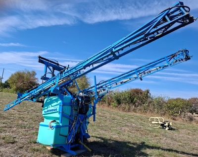 une machine bleue qui est posée dans l'herbe