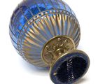 a blue vase with a gold lid on a white surface