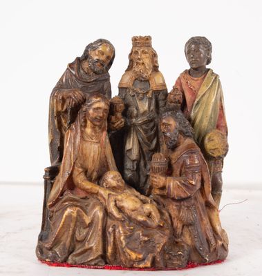 statue représentant un groupe de personnes assises autour d'une crèche avec un bébé
