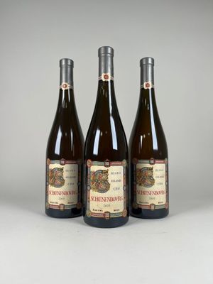 trois bouteilles de vin posées sur une table blanche