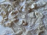 a lot of doily on a table with a pair of scissors