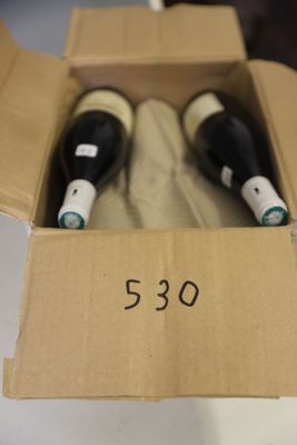 two bottles of wine in a cardboard box on a table